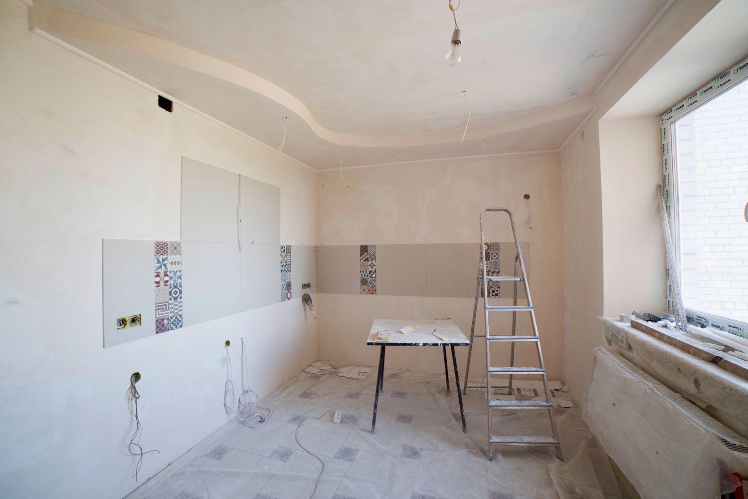 Interior room mid-renovation with fresh drywall and skim coat