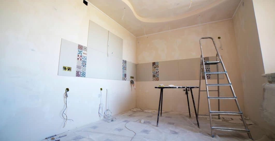 Contractor installing drywall panels on an interior wall