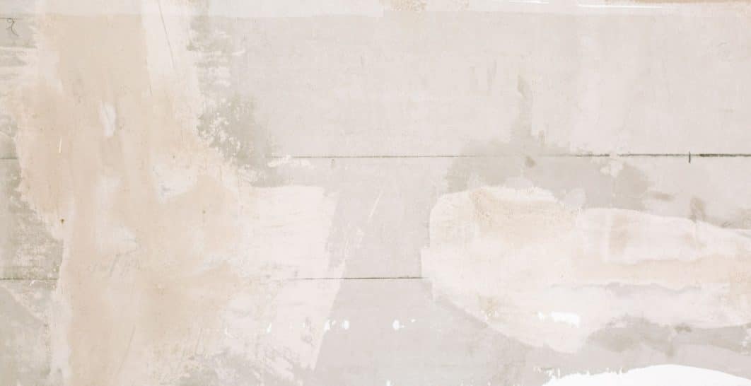 Finisher applying textured joint compound to a drywall surface with a trowel