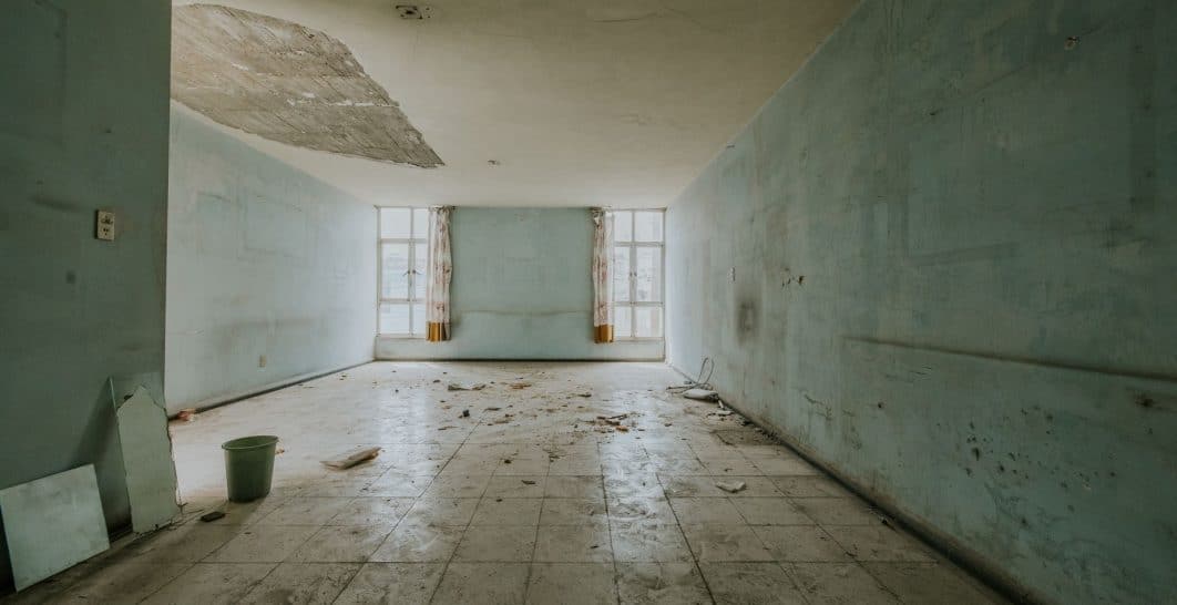 Brown water stain spreading across a white drywall ceiling