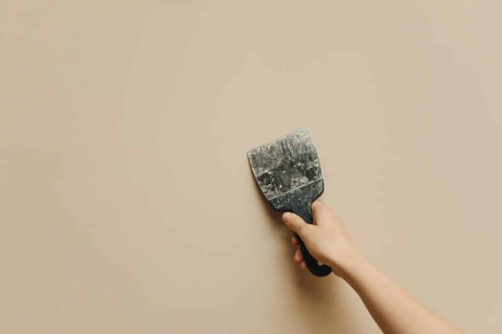 Finisher skim coating a wall to achieve a Level 5 drywall finish