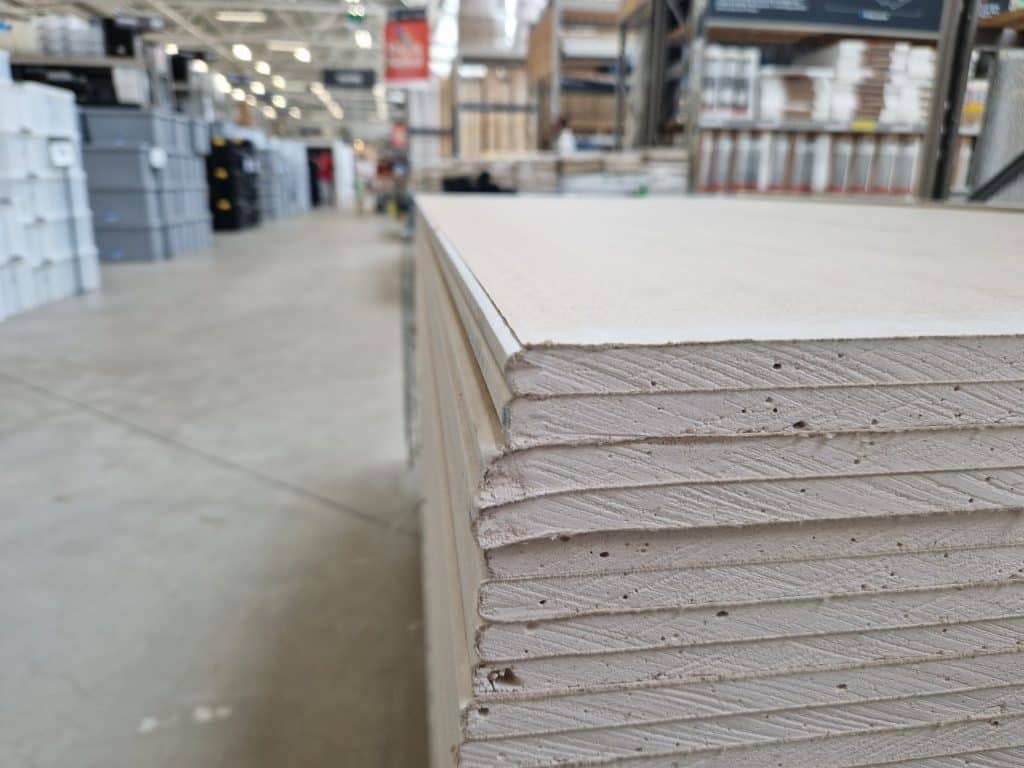 Stacked moisture-resistant drywall panels ready for installation in a humid climate