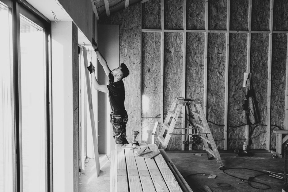 Close-up of a freshly finished drywall corner at a window opening, crisp corner bead line, ready for paint